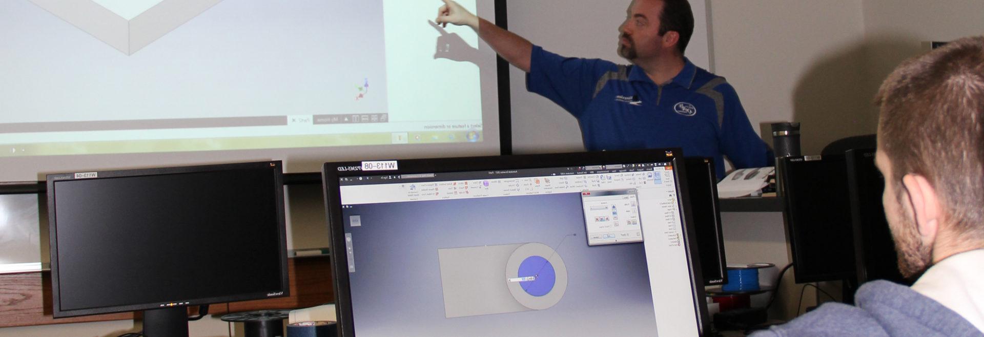 Instructor showing slides on the drop down screen